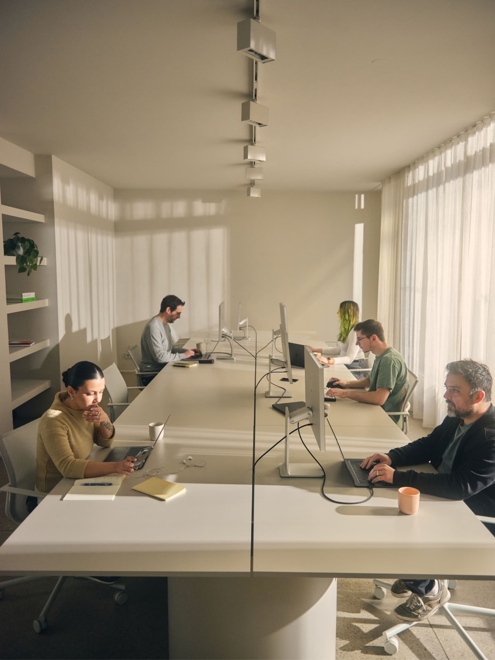 Several people working at computers in a bright, modern office space